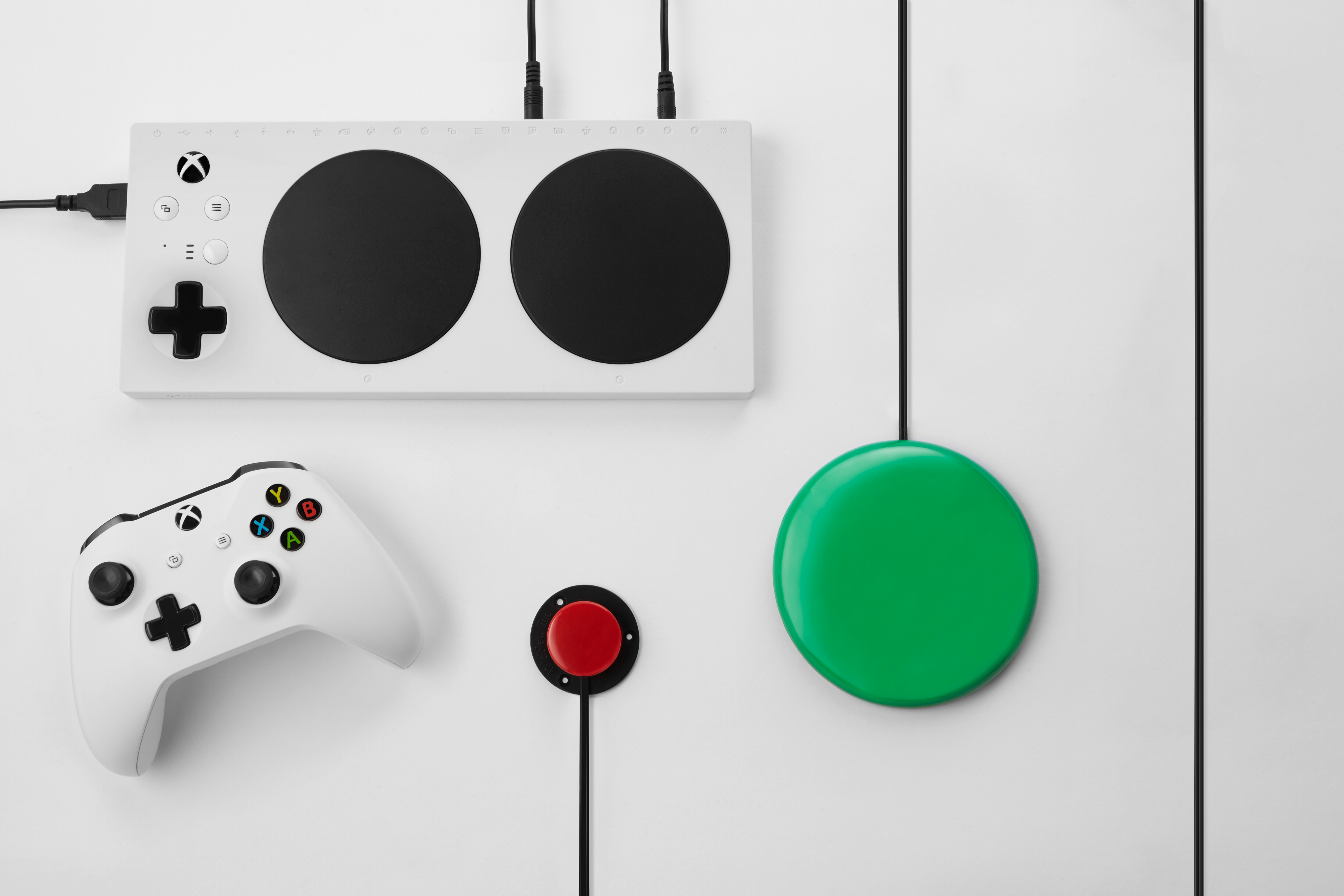 Microsoft's Xbox Adaptive controller with accessories and Xbox One controller.